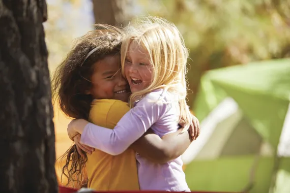 Two smiling girls hugging