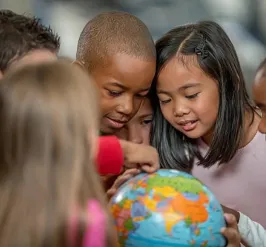 children looking at globe