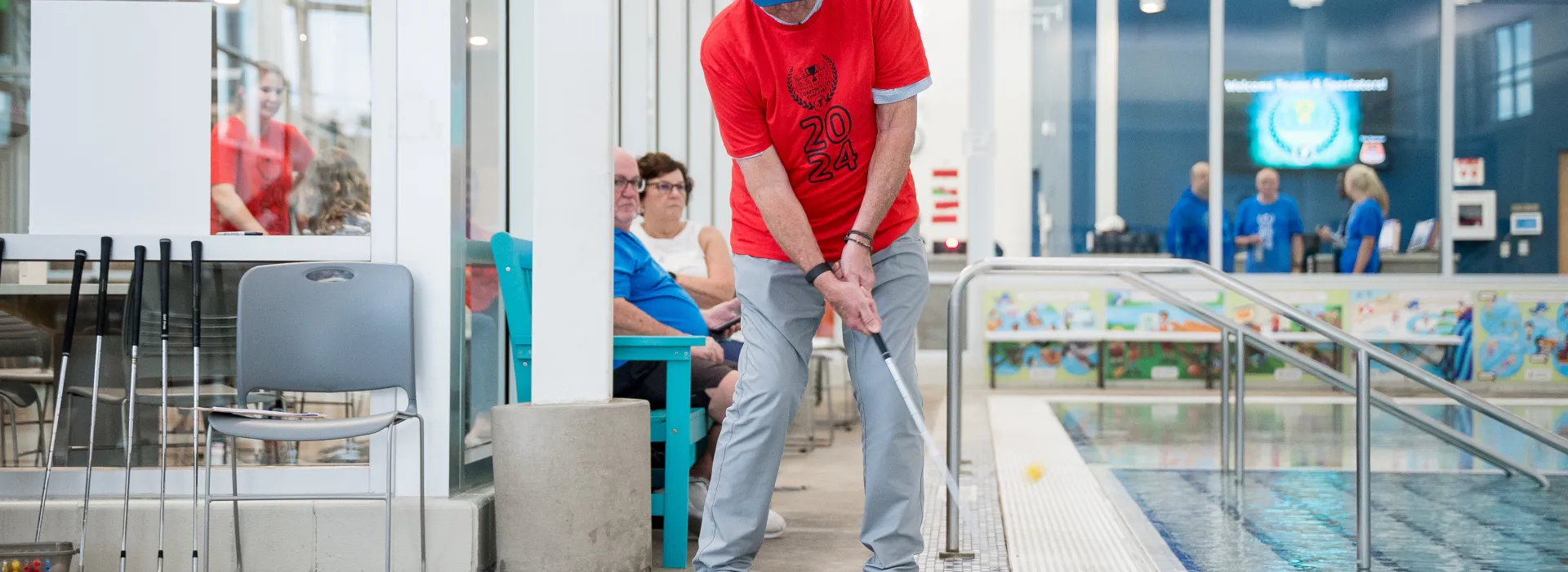Man chipping a golf ball into a pool