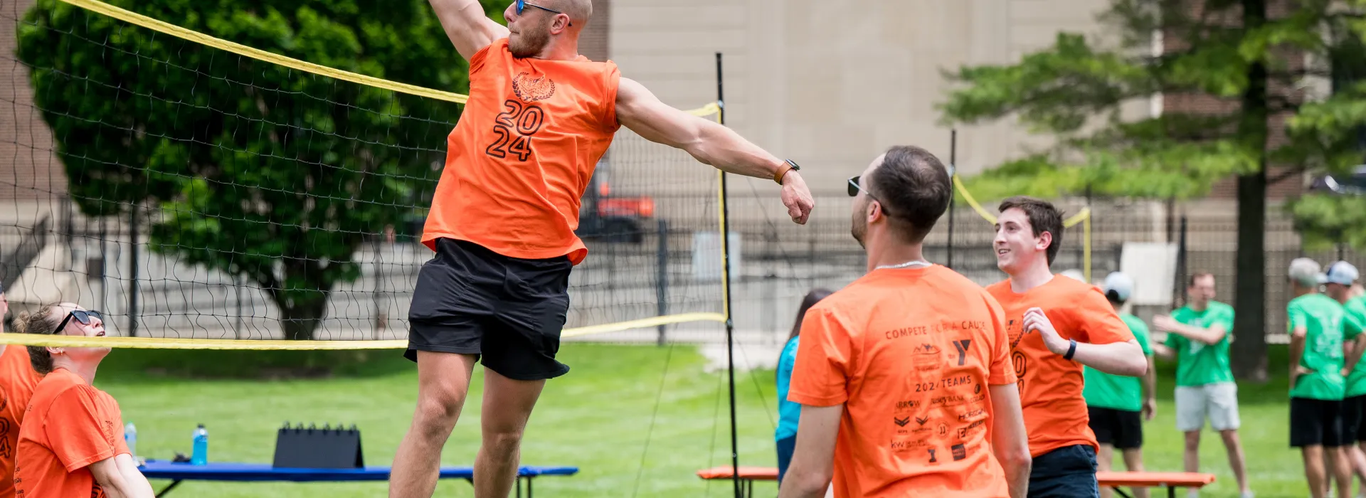 man spiking a volleyball over the net