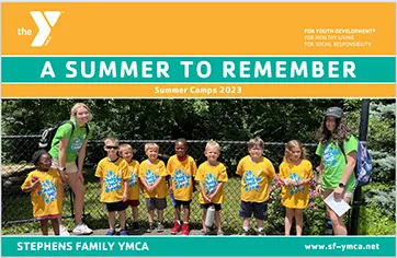 Group of children wearing yellow shirts with 2 counselors at summer camp